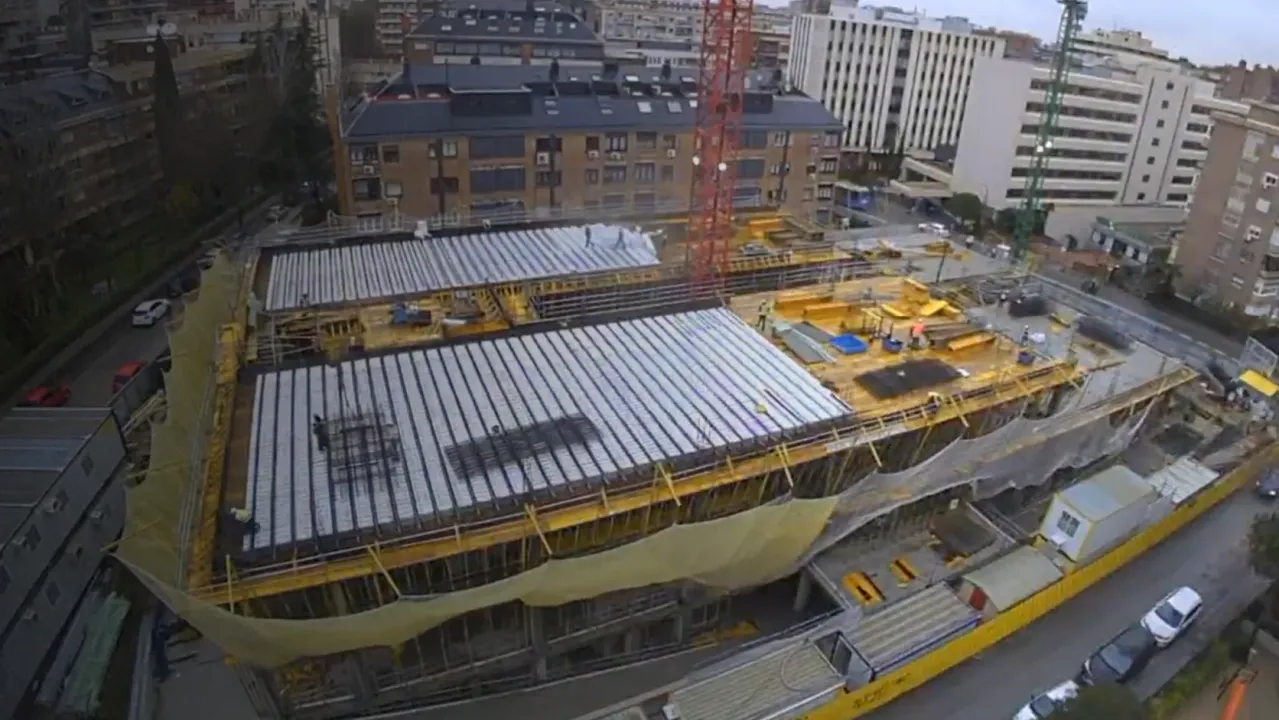 Vista aérea de un edificio en construcción rodeado de estructuras urbanas.