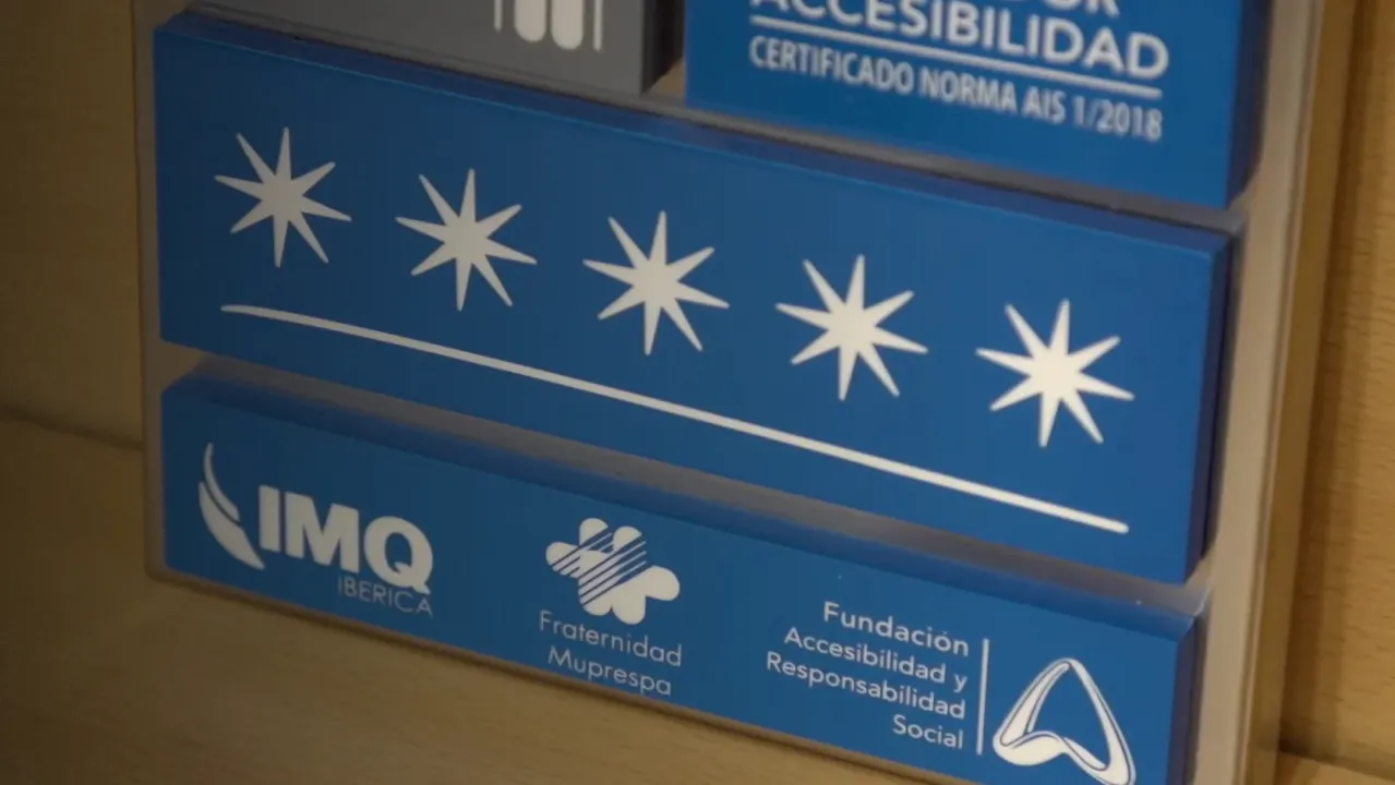 Placa azul con cinco estrellas blancas y el logo de IMQ, indicando certificación de accesibilidad.