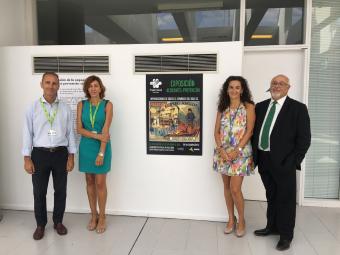 Representantes de Fraternidad-Muprespa y Aena, junto a uno de los carteles 