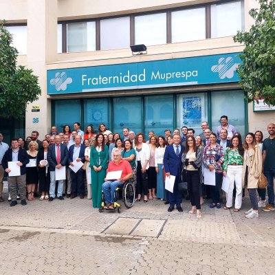 Foto de grupo de los asistentes al acto en la fachada de Fraternidad-Muprespa en Sevilla