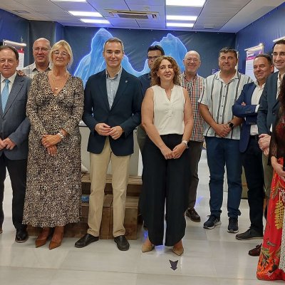 Grupo posando en una sala de exposición con paneles y vitrinas.