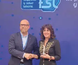 Fotografía de entrega de premios. Gráfico de home e muller interactuando.