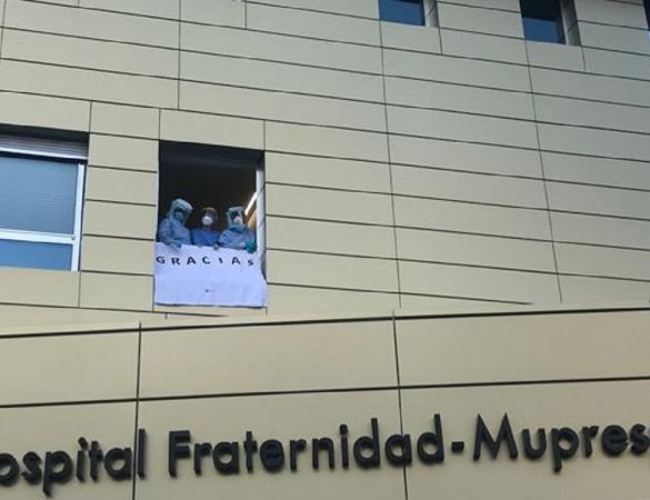 Trabajadores del Hospital Fraternidad-Muprespa Habana sostienen un cartel en el que se lee "Gracias" desde una ventana
