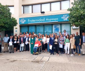 Foto de grupo de los asistentes al acto, ante la fachada de la dirección Provincial de Fraternidad-Muprespa en Sevilla 