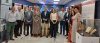 Grupo posando en una sala de exposición con paneles y vitrinas.